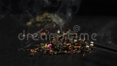 中国茶和中国木棍在黑色背景的黑桌上烟雾缭绕.. 现代寒冷的中国